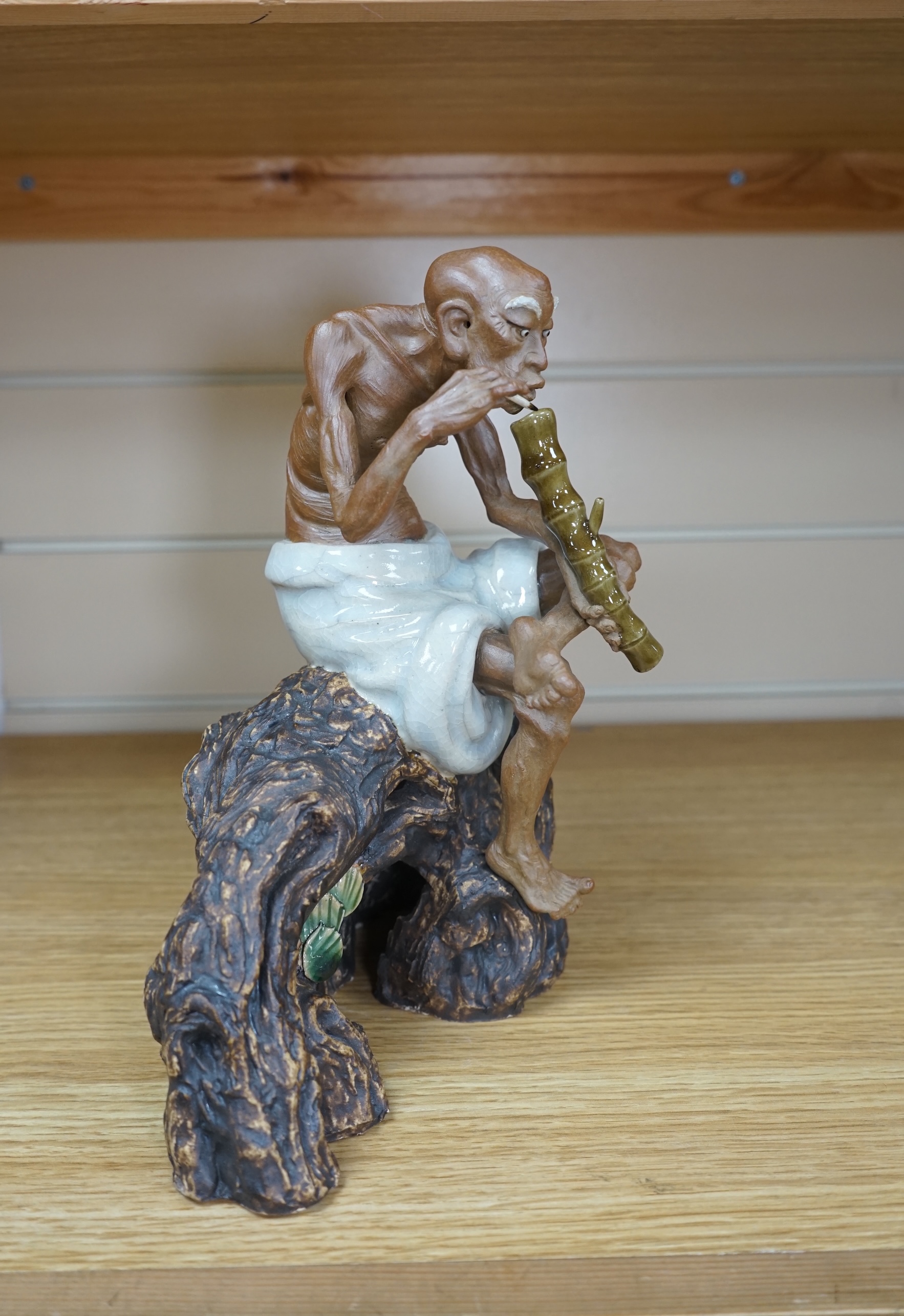 A 20th century Chinese figure of an opium smoker, maker’s seal to reverse and inscribed to interior base, 25cm. Condition - good